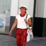 Una mujer pasea con una mascarilla personalizada por el centro de Sevilla
