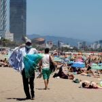 Un vendedor ambulante ofrece sus productos en la playa de Barcelona