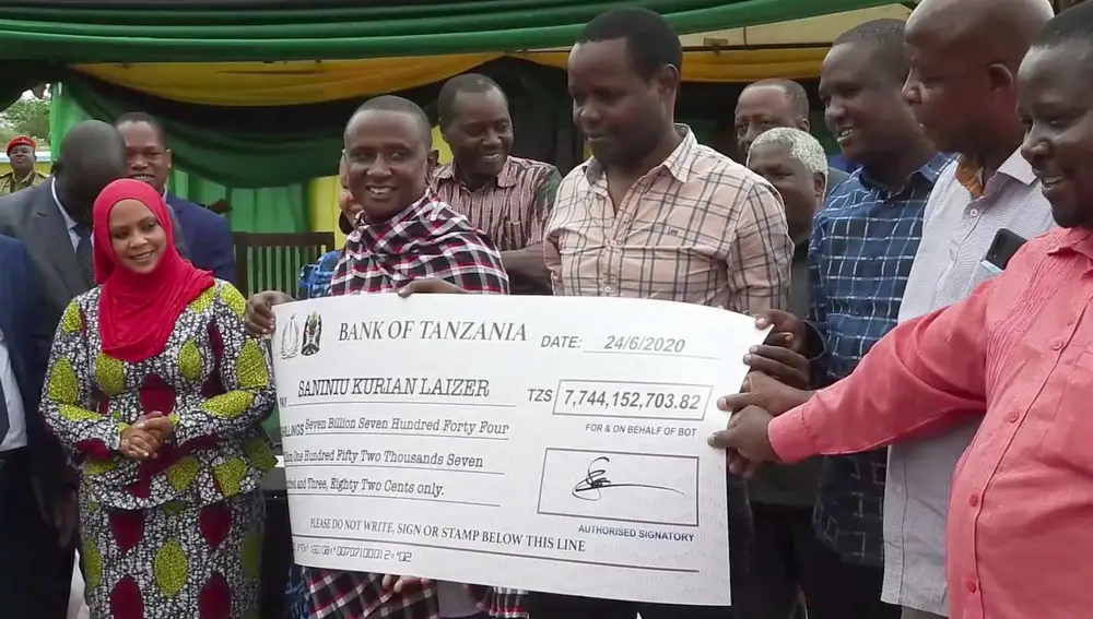 El minero Saniniu Laizer, en el centro izquierda de la imagen, recibe un cheque de los funcionarios gubernamentales por un valor de 7.744.152.703,82 chelines tanzanos (3,4 millones de dólares), en una ceremonia en Mererani, Tanzania, el miércoles 24 de junio de 2020. (AP Photo)