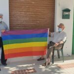 Dos vecinos de la localidad sujetan la bandera arcoíris tras la retirada de la misma en el Ayuntamiento