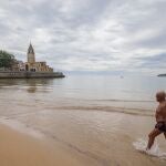 Un hombre sale de la playa de San Lorenzo de Gijón