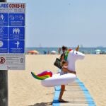 Una niña carga con su flotador hacia la orilla de la playa de Las Arenas de Valencia, en un sábado marcado por el sol y las altas temperaturas.