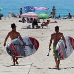 Dos surfistas disfrutan de un soleado día en la playa de Los Lances, en Tarifa (Cádiz), este domingo