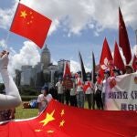 Manifestantes pro China ondean banderas para celebrar la aprobación de la Ley de Seguridad