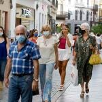 Transeúntes paseando por una calle de Sevilla tras el fin del estado de alarma