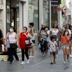Transeúntes pasean por Sevilla, equipados con mascarillas, después del estado de alarma