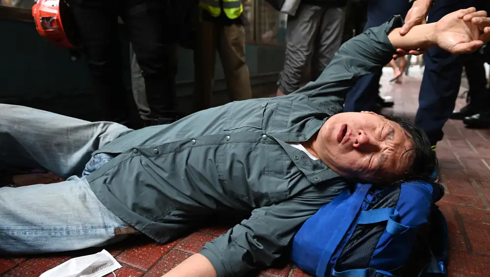 Un manifestante cae al suelo durante la protesta contra la ley de seguridad nacional china