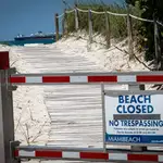 Vista de un cartel que indica que la playa está cerrada este sábado, en la entrada de la playa de Miami Beach, Florida (EEUU).