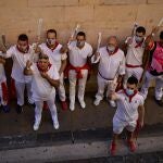 A group of would be participants wear face masks and sing a song along the route of the running of the bulls of the San Fermin festival, which was canceled this year due to the conoravirus, in Pamplona, northern Spain, Tuesday, July 7, 2020. (AP Photo/Alvaro Barrientos)