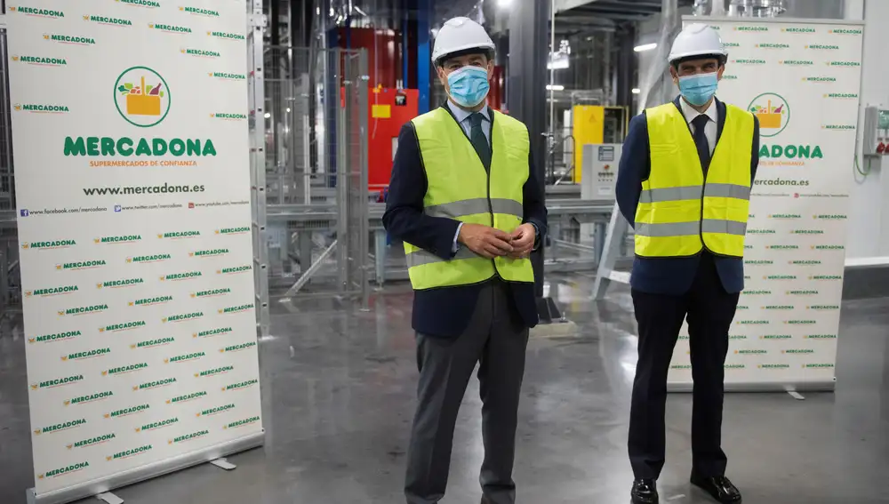 El presidente de la Junta de Andalucía, Juanma Moreno (i), visita la nave de congelados del bloque logístico de Mercadona, acompañado por el director de Relaciones Externas de Mercadona, Jorge Romero, en el ámbito de su visita a la localidad de Guadix, este jueves