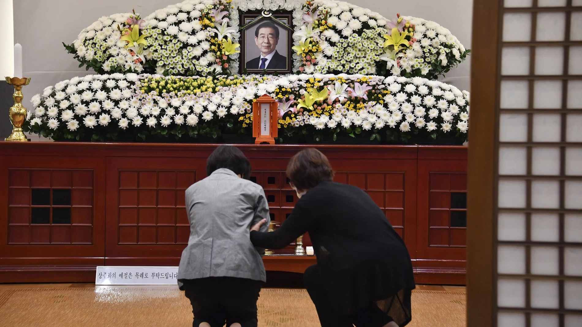 Dos mujeres lloran al fallecido alcalde Park Won Soon en un altar con su fotografía colocado en un hospital de Seúl