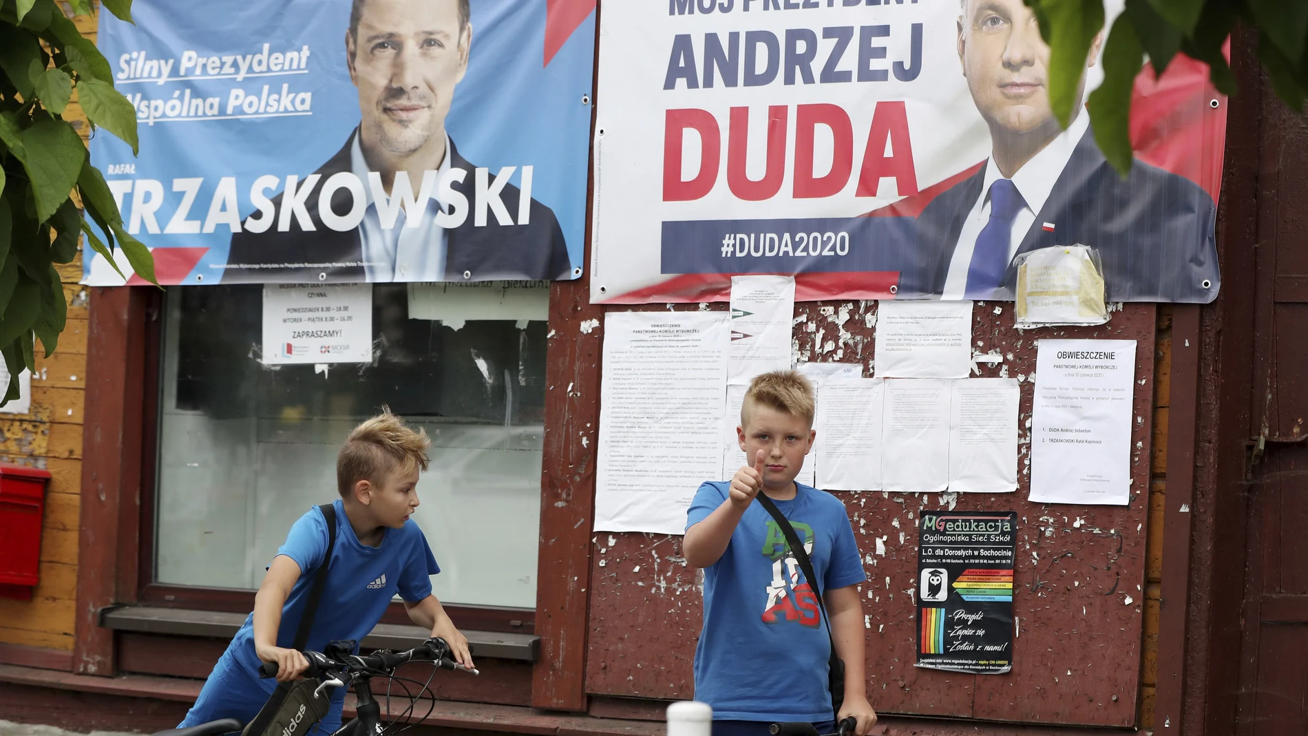 Dos niños polacos pasean junto a los carteles electorales del actual presidente, Andrzej Duda, y el candidato liberal, Rafal Trzaskowski, en Raciaz