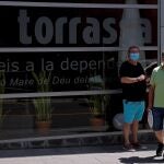 Familiares de unos residentes de la residencia "La Torrassa" esperan ante la puerta este sábado en L'Hospitalet de Llobregat donde un brote de la COVID-19 afecta a esta población barcelonesa.