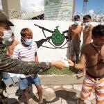 Un soldado brasileño reparte mascarilla a niños indígenas yanomamis el 30 de junio de 2020 en Alto Alegre (Brasil).