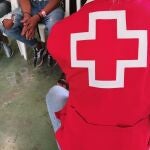 Un voluntario de Cruz Roja atiende a algunos inmigrantes