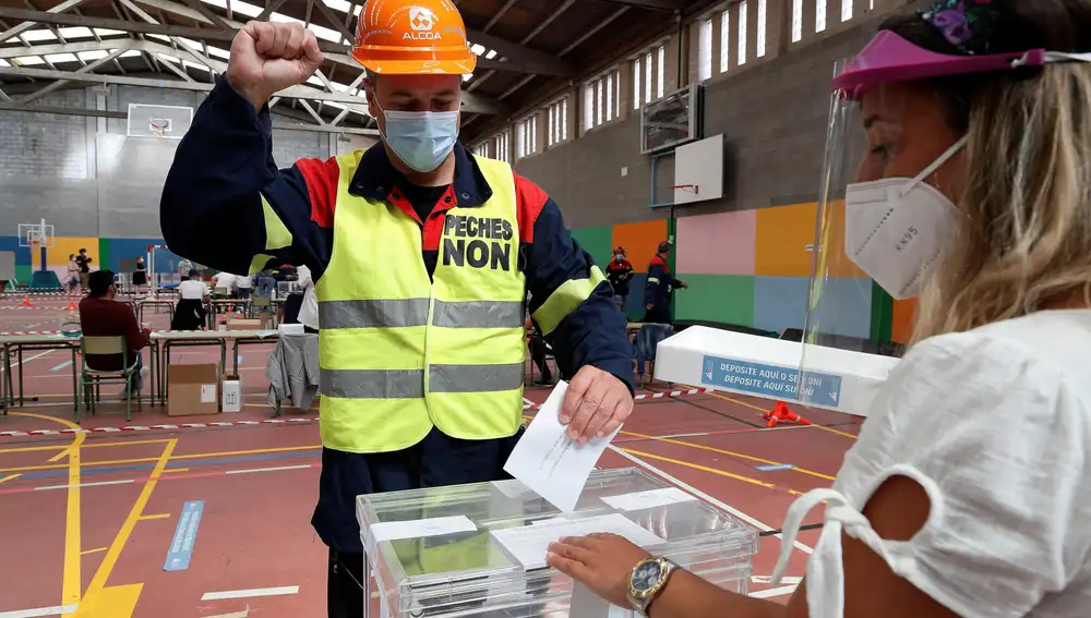 Un trabajador de ALCOA vota en un colegio electoral de Burela