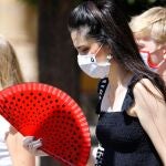 Imagen de archivo de varias mujeres caminando con mascarillas y abanicos en Córdoba