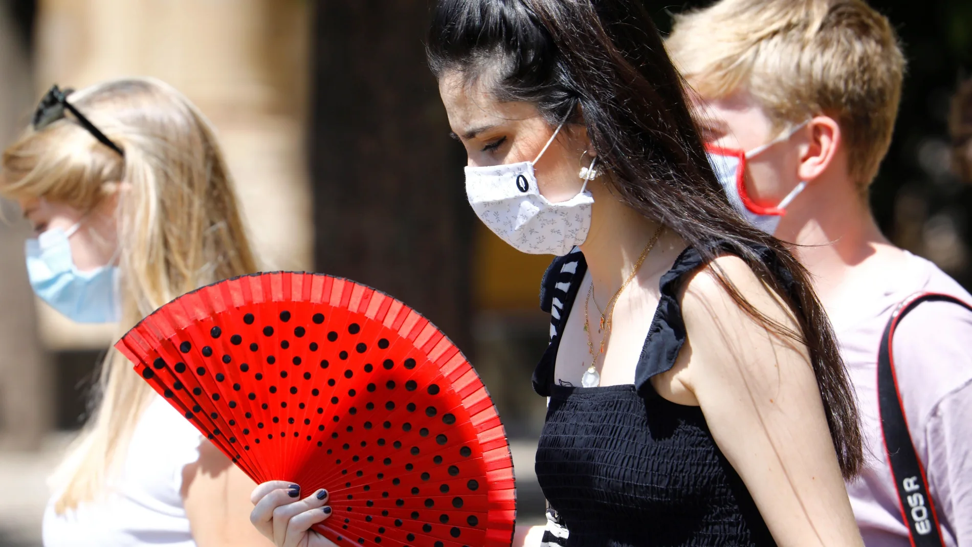 Imagen de archivo de varias mujeres caminando con mascarillas y abanicos en Córdoba