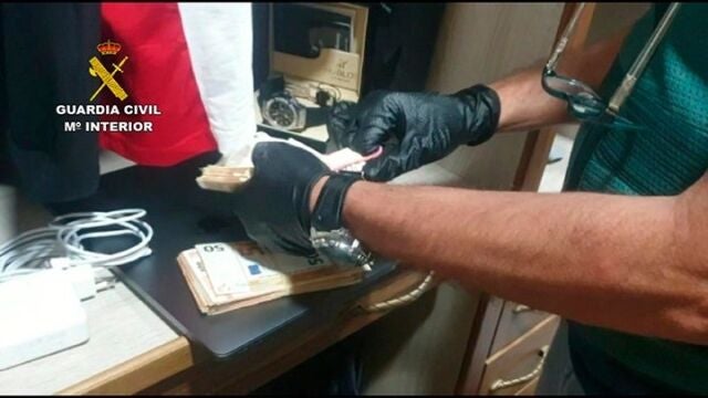 Un agente cuenta el dinero intervenido en uno de los registros de la operación por blanqueo de capitales