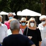 Varias personas caminan por una calle del centro de Córdoba con mascarillas