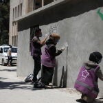 Voluntarios de una ONG pintan un grafiti en la fachada de un hospital de Idlib