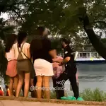 Un agente de policía advierte a unos jóvenes junto al río, en Sevilla