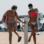 Dos mujeres, protegidas con mascarillas, en la playa de La Malvarrosa, el pasado verano.