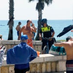 Policía Local informa a un bañista en la playa de La Malagueta