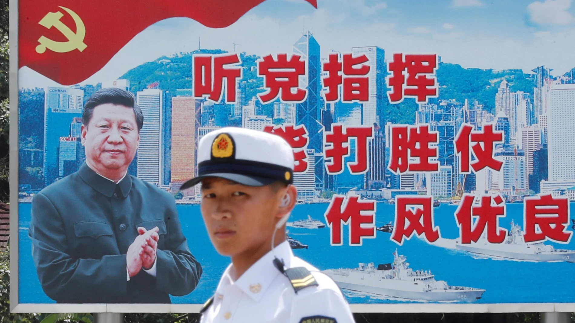 FILE PHOTO: People's Liberation Army Navy soldier stands in front of a backdrop featuring Chinese President Xi Jinping during an open day of Stonecutters Island naval base, in Hong Kong