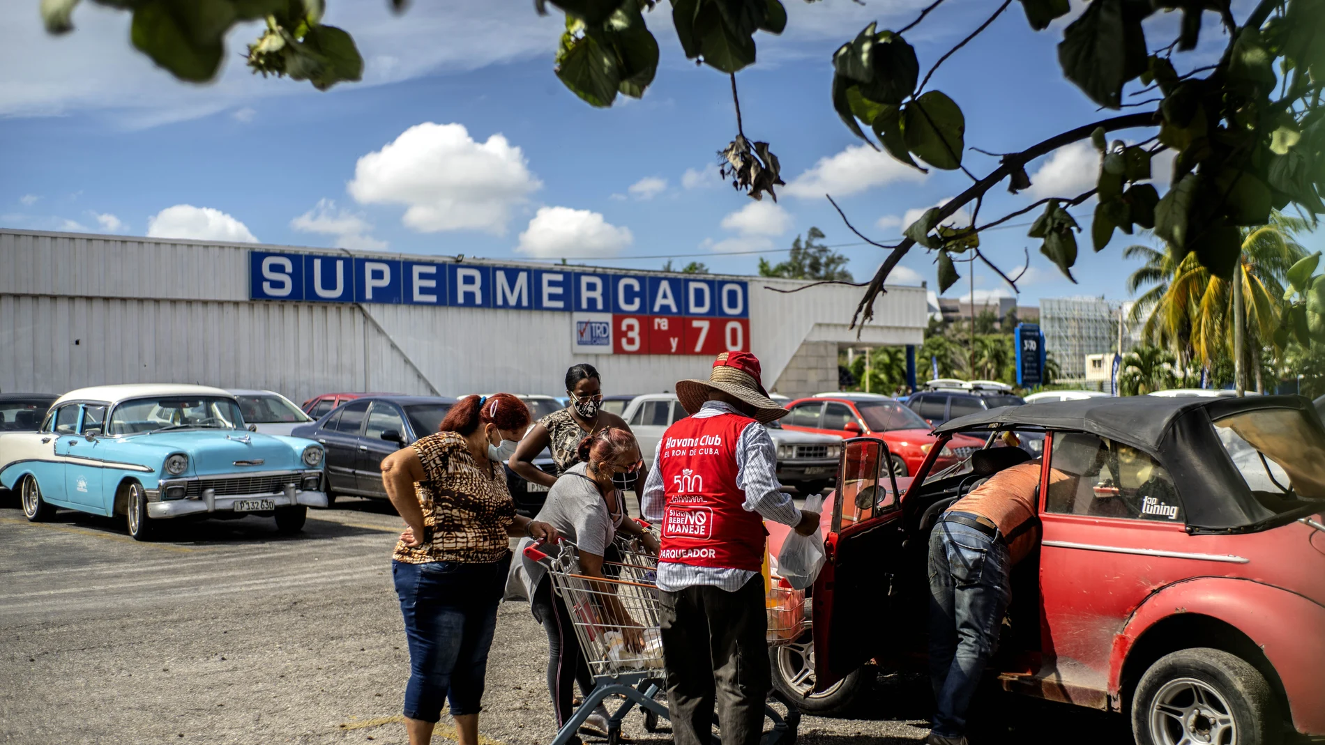Shoppers wearing protective facemasks amid the spread of the new coronavirus load groceries from a dollar store in Havana, Cuba, Monday, July 20, 2020. Cuba has expanded the types of stores that accept dollars for payment to include food stores, as part of the governmentâ€™s effort to capture much needed hard currency to shore up the islandâ€™s ailing economy. (AP Photo/Ramon Espinosa)