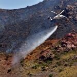 Un helicóptero del Plan Infoca trabajando junto a dos grupos de especialistas y una Brigada de Refuerzo Contra Incendios de la comunidad autónoma de Andalucía (Brica), con 25 bomberos forestales, para extinguir el incendio forestal declarado en el paraje Las Negras, en el término municipal de Níjar (Almería)