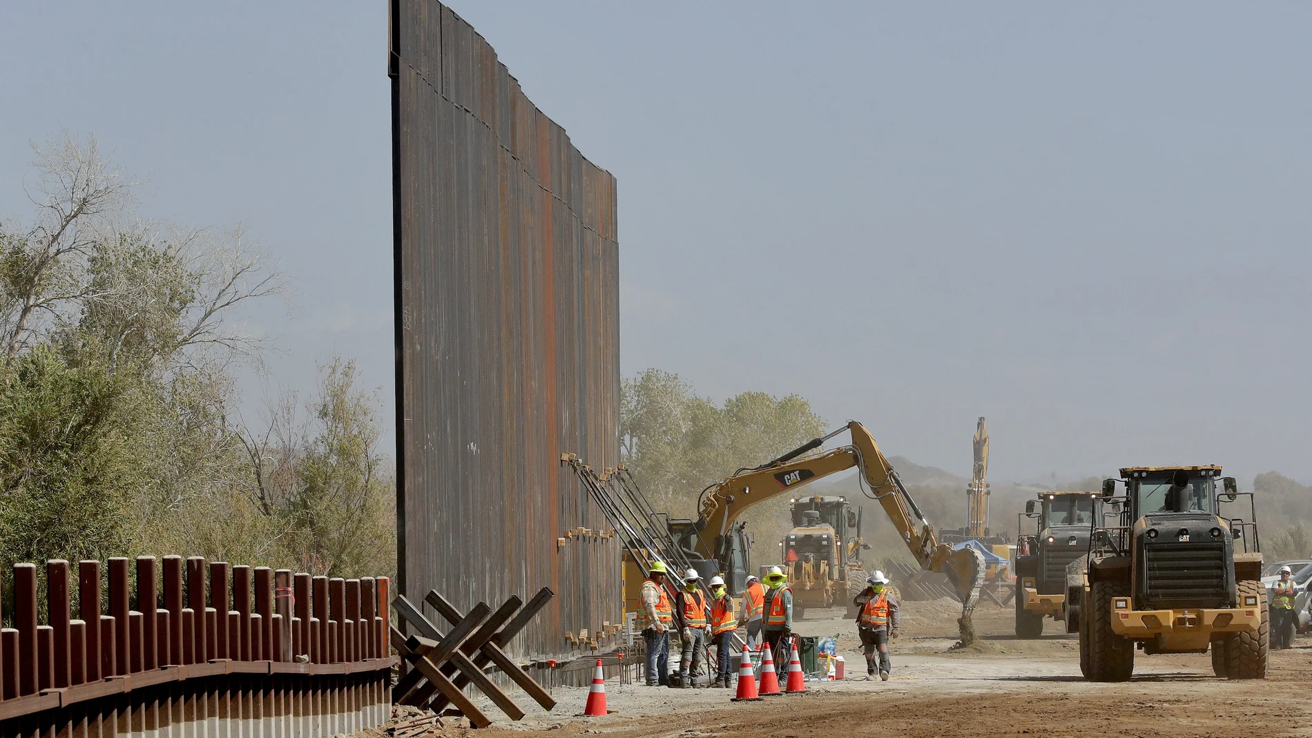 FILE - In this Sept. 10, 2019 file photo government contractors erect a section of Pentagon-funded border wall along the Colorado River in Yuma, Ariz. The federal Bureau of Land Management said on Tuesday, July 21, 2020, it's transferred over 65 acres of public land in Arizona and New Mexico to the Army for construction of border wall infrastructure. (AP Photo/Matt York,File)
