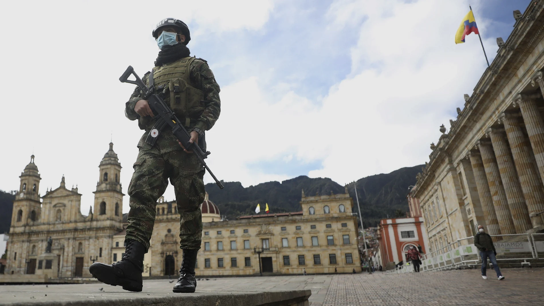 A soldier wearing a protective face mask walks in Bolivar Square in Bogota, Colombia, Tuesday, July 21, 2020, amid the new coronavirus pandemic. (AP Photo/Fernando Vergara)