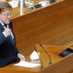 El presidente de la Generalitat, Ximo Puig, responde, en el pleno de Les Corts, a las preguntas de los síndics de los grupos parlamentarios sobre la crisis económica, social y sanitaria derivada de la pandemia por coronavirus.