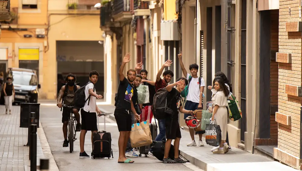 Un grupo de jóvenes turistas se encuentra con amigos a la salida de un apartamento turístico de bajo coste