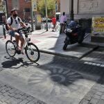 Un ciclista pasa por encima de un distintivo de Madrid Central en Madrid