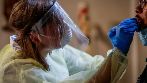 Una enfermera hace un test de coronavirus a en una iglesia convertirda en centro anti covid en Antwerp