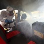 Un trabajador desinfecta un taxi en Bogotá