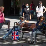 Una pareja de turistas británicos descansa en un banco de las Ramblas en Barcelona