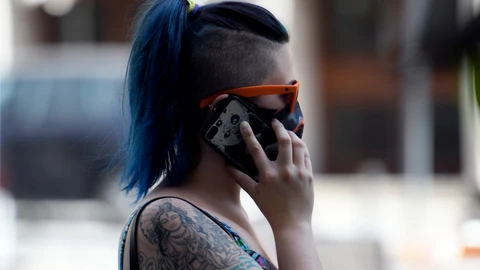 Una mujer con mascarilla habla por teléfono, en Madrid (España) a 30 de julio de 2020. - Óscar Cañas - Europa Press