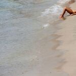 Una mujer toma el sol en la playa de Benidorm (Alicante)
