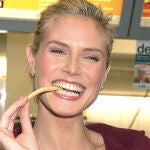 La modelo Heidi Klum comiendo patatas fritas.