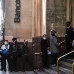 Personas hacen fila en un banco en Buenos Aires en una foto de archivo