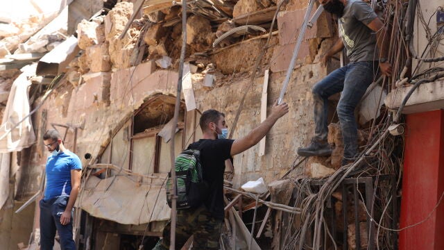 Jóvenes comprueban los daños en los edificios del área portuaria de Beirut tras la explosión del martes