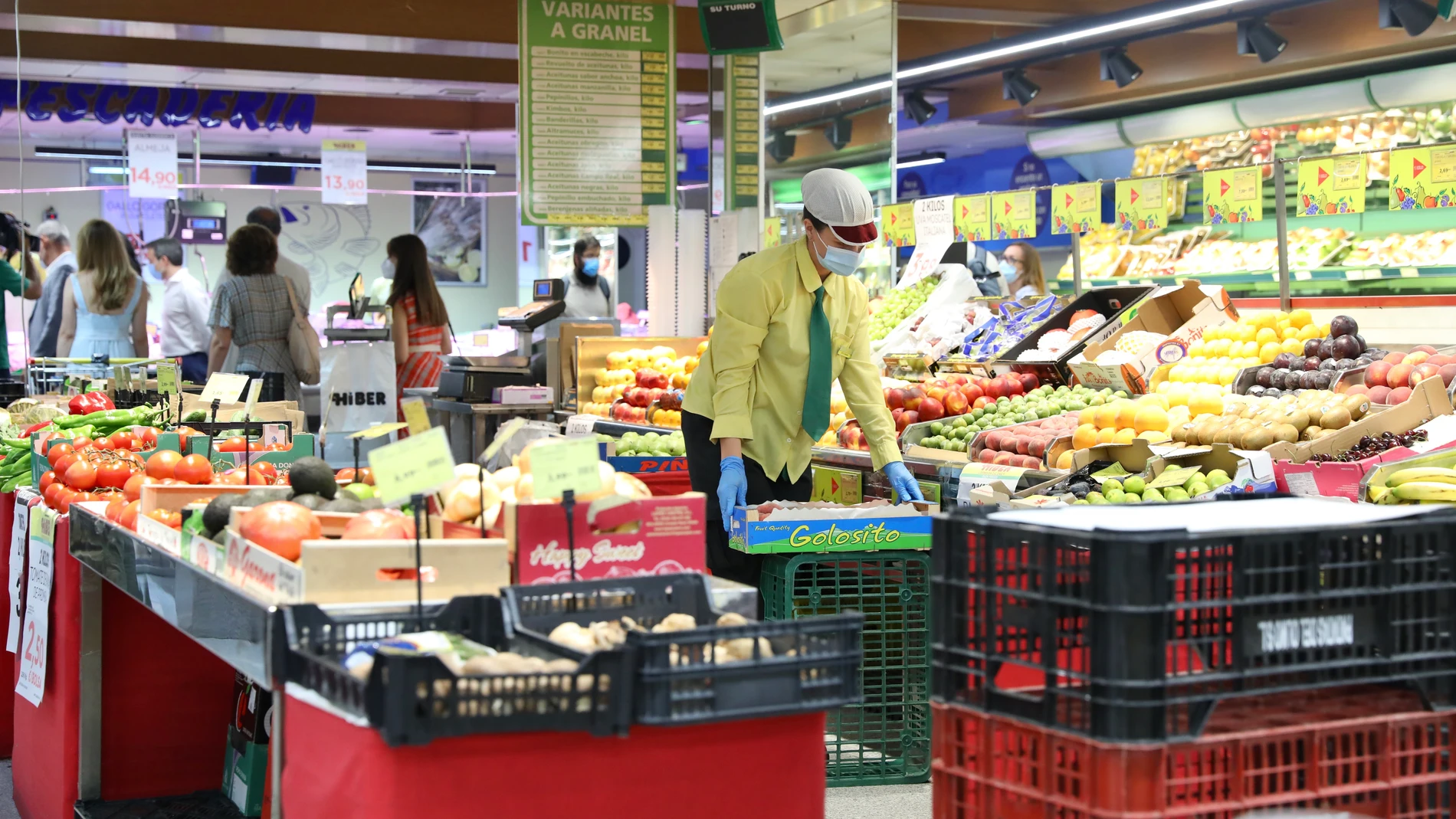 Una trabajadora coloca las frutas y verduras en un supermercado.