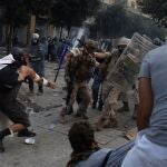 Un manifestante golpea a un policía durante las protestas en Beirut