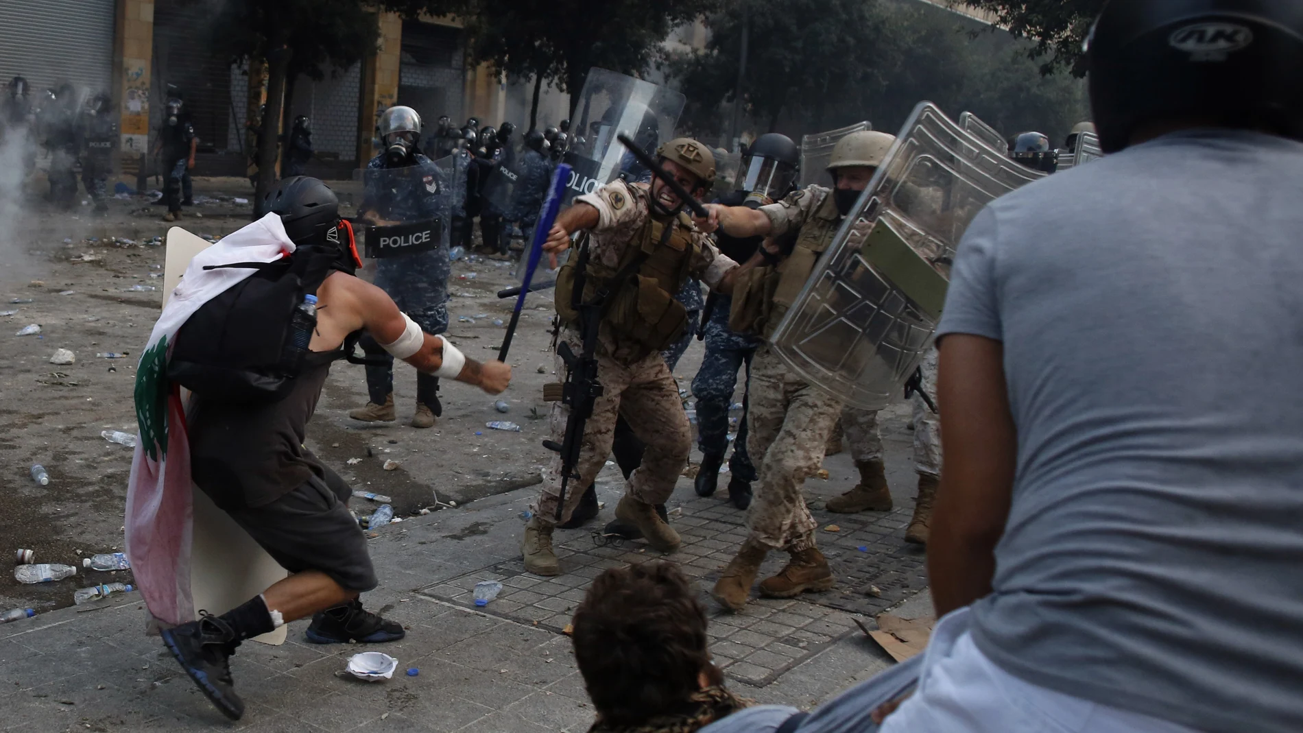 Un manifestante golpea a un policía durante las protestas en Beirut