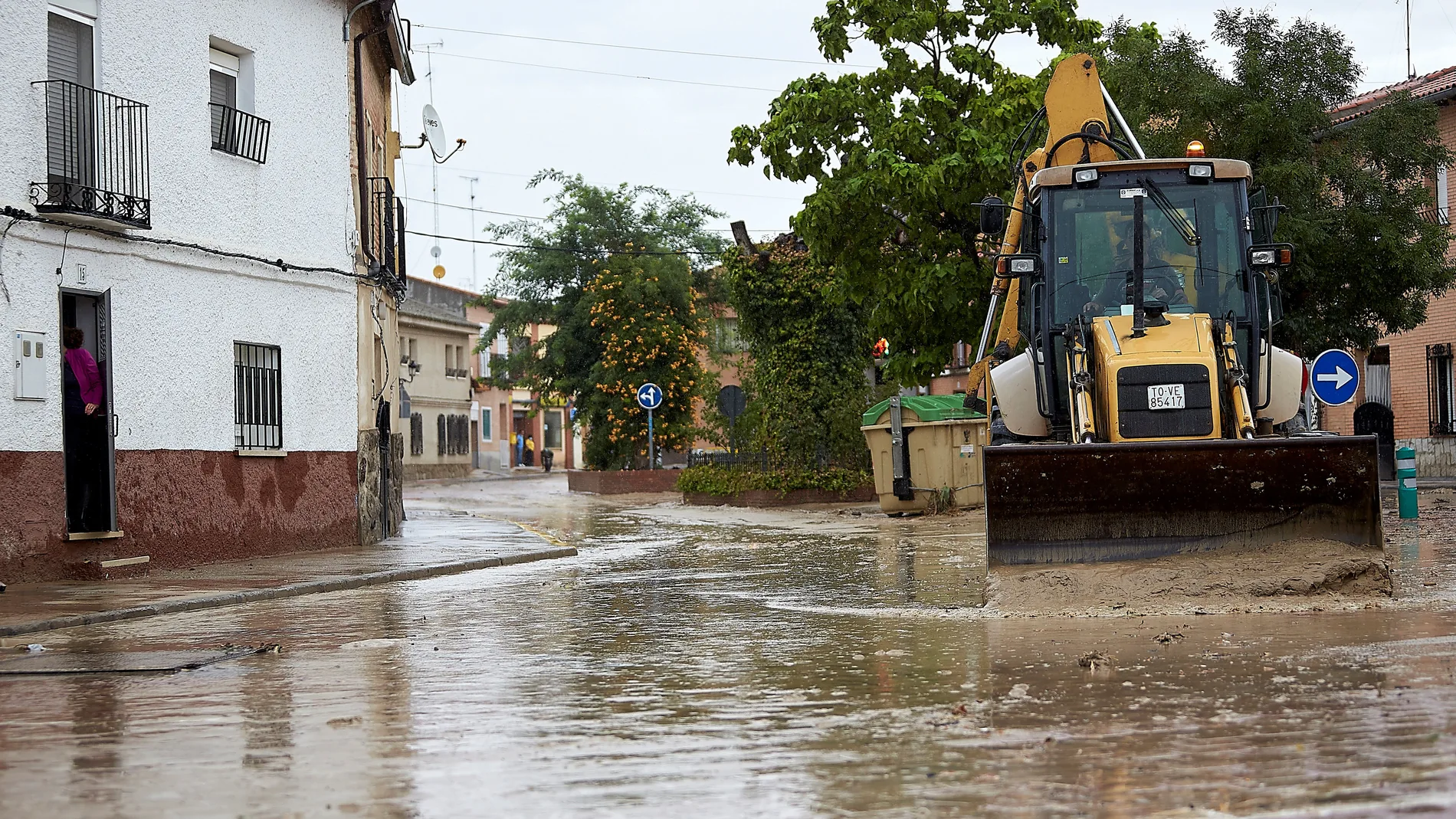 Un tractor limpia las calles de Cebolla (Toledo) cubiertas por el lodo tras las lluvias caídas en la región