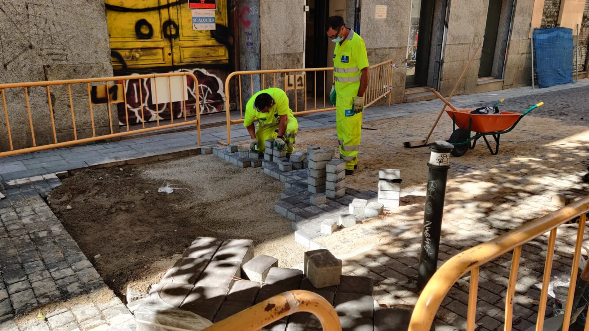 Unos operarios ponen los adoquines en una de las calles del centro de Madrid