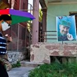 Una mujer camina hoy frente a una imagen de Fidel Castro colgada en una casa de La Habana (Cuba).